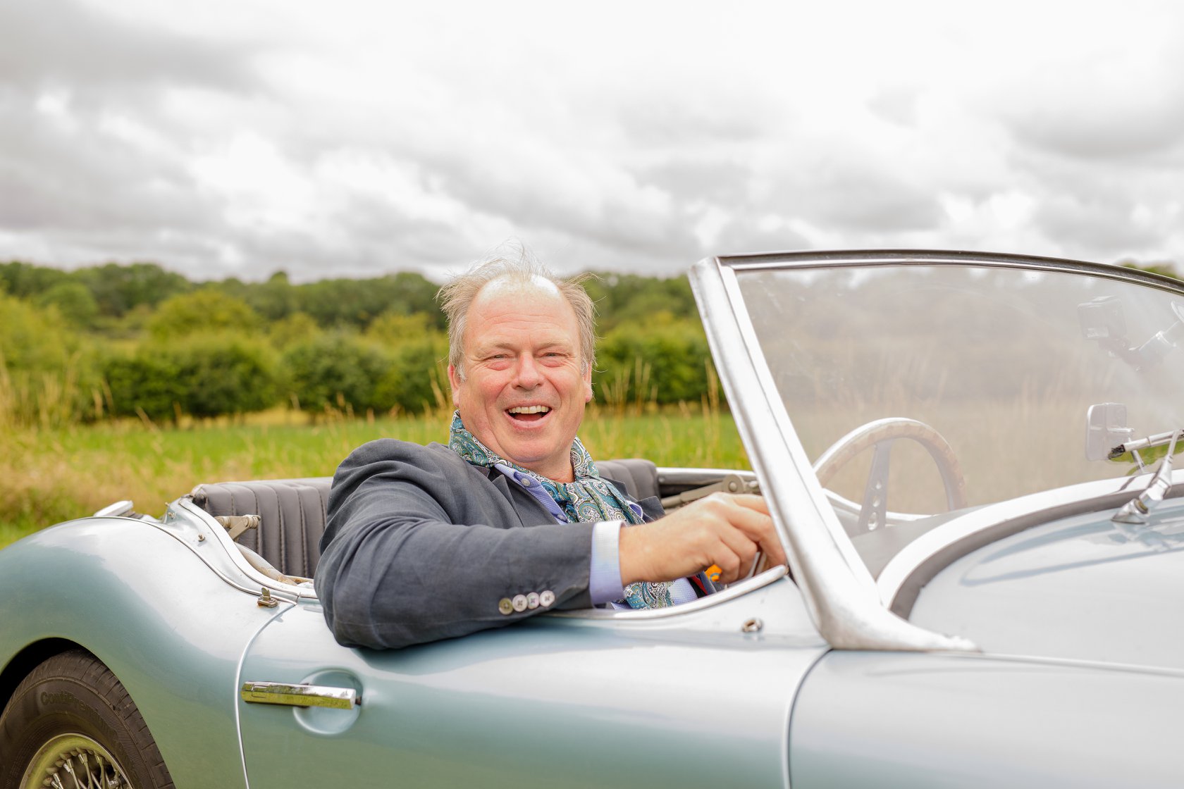 Smiling man in open top car